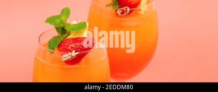 Bunte erfrischende Erdbeer orange Sonnenaufgang Cocktail-Getränke in den Gläsern Auf korallenrosa Banner Hintergrund Stockfoto