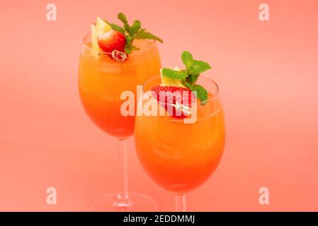 Bunte erfrischende Erdbeer orange Sonnenaufgang Cocktail-Getränke in den Gläsern Auf korallenrosa Hintergrund Stockfoto