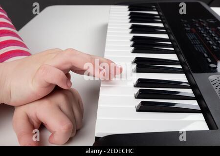 Lernen, Klavier zu spielen, kleine Mädchen Hände auf Synthesizer-Tasten Stockfoto