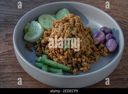 Südlicher Schweinebrick mit gelber Curry-Paste serviert mit violetter Aubergine, Gurke und Yard Long Bohne. Selektiver Fokus. Stockfoto