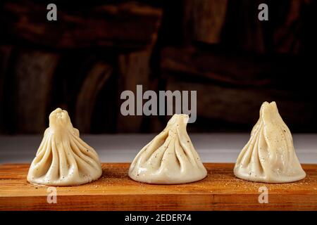 Georgische hausgemachte Speisen genannt khinkali auf Holzbrett Stockfoto