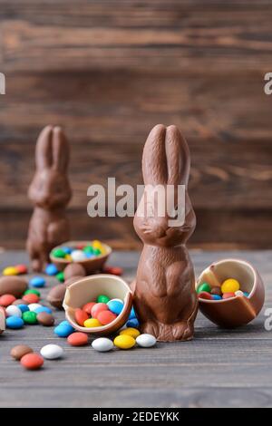 Leckere Schokolade Osterhase und Eier mit Süßigkeiten auf Holz Hintergrund Stockfoto