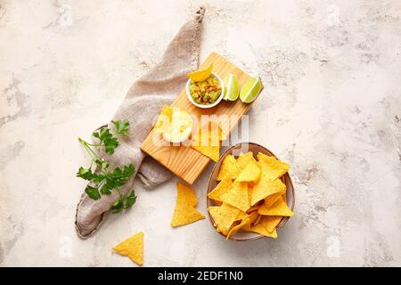 Leckere Nachos in Teller und Brett mit Soßen auf Licht Hintergrund Stockfoto