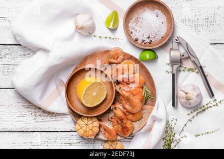 Teller mit leckeren Garnelen und Zitrone auf Holzgrund Stockfoto