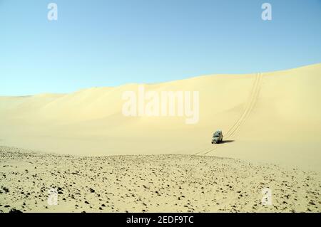 Eine Wüsten Safari Land Cruiser 4x4 Jeep Wappen eine riesige Sanddüne im Sandmeer der Westlichen Wüste, ägyptische Sahara, Ägypten. Stockfoto