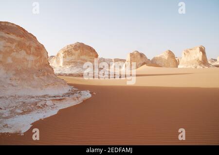 Weiße Kalkfelsen und Inselberge gemischt mit Sand im White Desert National Park, in der Farfara Depression, Sahara-Region, von Ägypten. Stockfoto