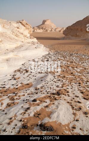 Weiße Kalkfelsen und Inselberge gemischt mit Sand im White Desert National Park, in der Farfara Depression, Sahara-Region, von Ägypten. Stockfoto