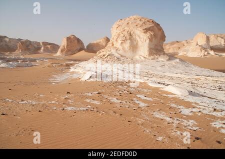 Weiße Kalkfelsen und Inselberge gemischt mit Sand im White Desert National Park, in der Farfara Depression, Sahara-Region, von Ägypten. Stockfoto