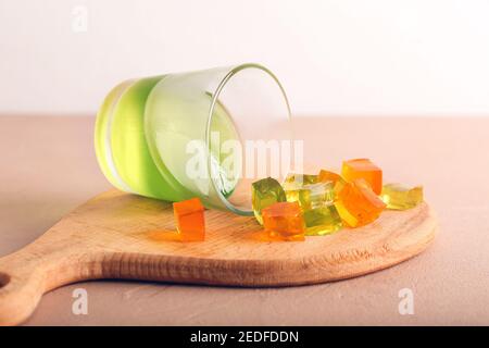 Glas mit leckeren Geleewürfeln auf dem Tisch Stockfoto