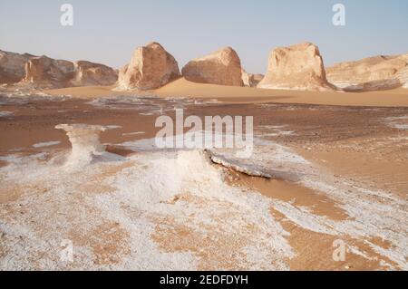 Weiße Kalkfelsen und Inselberge gemischt mit Sand im White Desert National Park, in der Farfara Depression, Sahara-Region, von Ägypten. Stockfoto