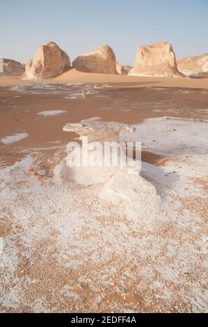 Weiße Kalkfelsen und Inselberge gemischt mit Sand im White Desert National Park, in der Farfara Depression, Sahara-Region, von Ägypten. Stockfoto