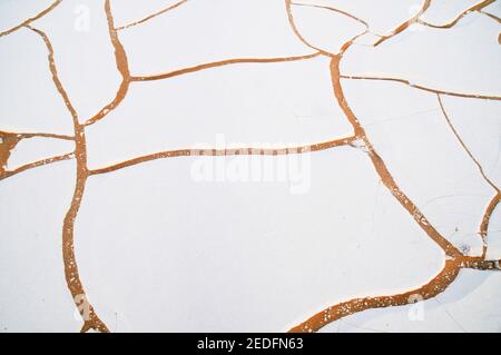 Weiße Kalkfelsen und Sand auf dem Wüstenboden im White Desert National Park, in der Farfara Depression, Sahara-Region, von Ägypten. Stockfoto