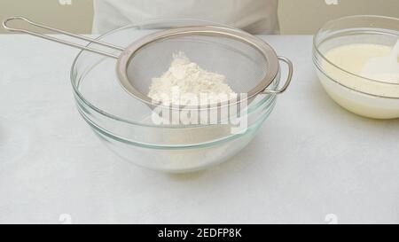 Schokoladenkuchen Schritt für Schritt Rezept. Mischen von trockenen Zutaten in einer Glasschüssel, Nahaufnahme Stockfoto