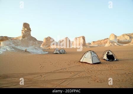Ein Wüstensafari Camp inmitten von weißen Felsformationen und Inselbergen im White Desert National Park, in der Farfara Depression, Sahara Region, Ägypten. Stockfoto