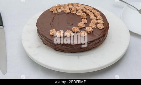 Hausgemachte Schokoladenkuchen mit Schokoladencreme-Zuckerguss und Schokoladenganache Nahaufnahme des Drahtgestells auf dem Küchentisch Stockfoto