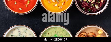 Vegane Suppe Panorama-Hintergrund mit einer Auswahl an Cremesuppen und ein Ort für Text, Top-shot, flach lag auf schwarzem Hintergrund Stockfoto