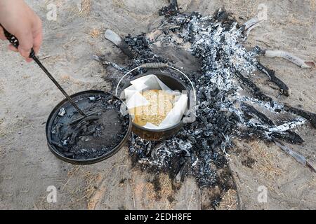 Dämpfer oder Brot, das in einem Zeltplatz gebacken wird, oder Kochtopf, über einem Lagerfeuer im Outback im Lorella Springs Wilderness Park, nahe Borroloola, Norther Stockfoto