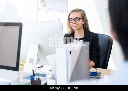 Lächelnd glücklich Geschäftsfrau weißen Kragen Arbeiter konzentriert sich auf die Arbeit mit Desktop-Computer im Büro Stockfoto