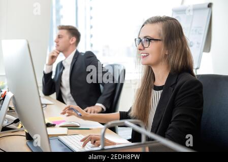 Lächelnd glücklich Geschäftsfrau weißen Kragen Arbeiter konzentriert sich auf die Arbeit mit Desktop-Computer im Büro Stockfoto