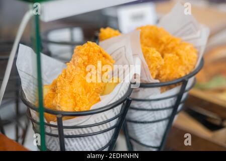 Gebratener Fisch oder Huhn im Teig in Zeitung eingewickelt Lebensmittelmarkt - Nahaufnahme Stockfoto