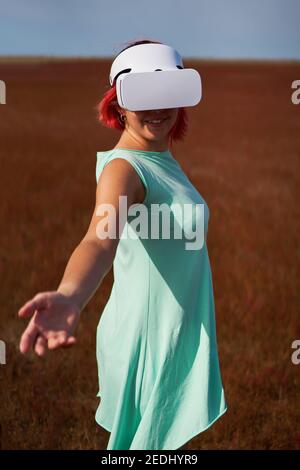 Frau geht in die virtuelle Realität mit Virtual-Reality-Headset. Das Konzept der virtuellen Realität, Simulationen, Verbindung und Kommunikation. Stockfoto