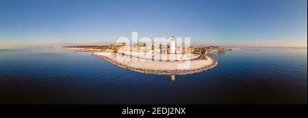 Panoramablick auf den Leuchtturm von Urk Flevoland Niederlande, Urk im Winter mit weißem Schnee bedeckt den Strand. Winter in den Niederlanden Stockfoto