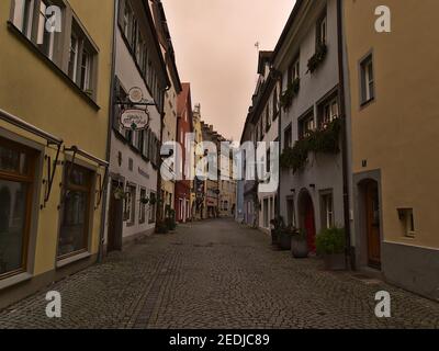 Leere Gasse mit alten Gebäuden im Stadtzentrum am bewölkten Wintertag. Orangefarbener Himmel aufgrund von Wetterphänomen (Sahara-Wüstensand in der Luft). Stockfoto