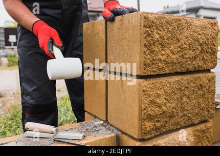 Zementmörtel zum Verkleben von Betonblöcken beim Bau von Ein Zaun Wand - Mauerwerk Stockfoto