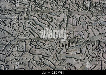 Tote und sterbende Krieger und ihre Pferde auf dem Schlachtfeld von Kadesch. Altägyptischer Stein geschnitzter Fries auf dem zweiten Mast des Ramesseum, Luxo Stockfoto