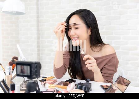 Schöne asiatische Frau professionelle Schönheit vlogger oder Blogger tun Kosmetik Make-up Tutorial Video auf Social Media teilen Stockfoto