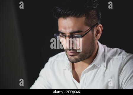 Handsome asiatischen Geschäftsmann konzentriert sich auf die Arbeit in der Nacht mit ernst Gesicht Stockfoto