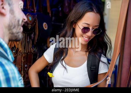 Paar Touristen, die sich Lederprodukte im Einkaufsstand angucken Outdoor-Markt während der Reise in Bangkok Thailand Stockfoto