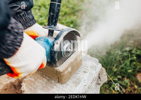 Betonpflasterplatten verlegen - die Arbeit eines Meisters Auf einer Baustelle Stockfoto