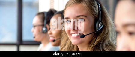 Schöne Frau trägt Mikrofon-Headset arbeitet im Call Center mit internationalen Team als Telemarketing-Kundendienst Agenten, Panorama-Banner Stockfoto