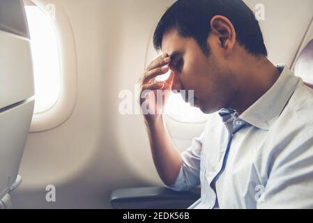 Der männliche Passagier fühlt sich schwindlig, wenn er auf der Reise Luftkrankheit hat Ebene Stockfoto