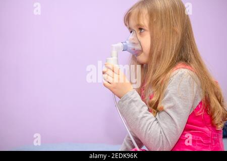 Kinder mit asthmatischen Problemen nehmen Einatmen mit Maske im Gesicht, Haustherapie. Stockfoto