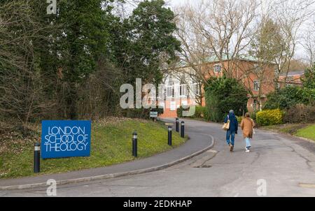 Ein Mann und eine Frau gehen in den Straßeneingang der London School of Theology, ehemals London Bible College, Green Lane, Northwood, Middlesex, England, VEREINIGTES KÖNIGREICH Stockfoto