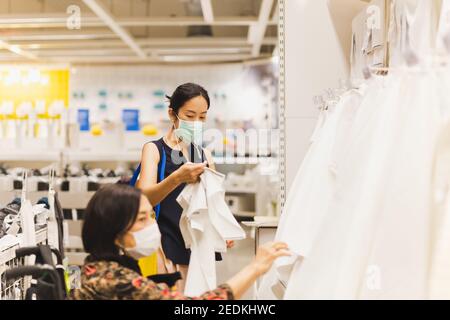 Ältere Frau im Rollstuhl mit Tochter beim Einkaufen im Geschäft. Stockfoto