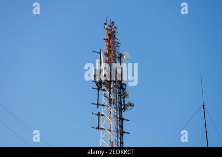 Turm mit Sendeantennen gegen den blauen Himmel. Hochwertige Fotos Stockfoto