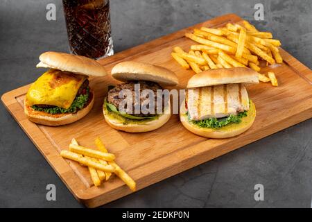 Drei Mini-Burger mit Huhn und Fleisch serviert mit französisch Pommes Stockfoto