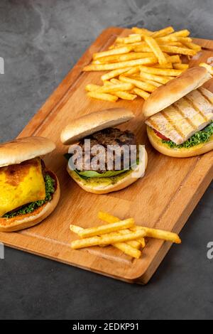 Drei Mini-Burger mit Huhn und Fleisch serviert mit französisch Pommes Stockfoto