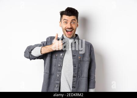 Gut gemacht, Sehr gut. Aufgeregt gut aussehenden Kerl lobende schöne Arbeit, zeigt Daumen hoch und lächelt glücklich, genehmigen genial Wahl, auf weiß stehen Stockfoto