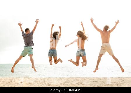 Glückliche junge energetische Gruppe von Freunden springen am Strand in den Sommerferien, Spaß und Freiheit Konzepte Stockfoto