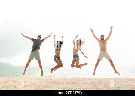 Glückliche junge energetische Gruppe von Freunden springen am Strand in den Sommerferien, Spaß und Freiheit Konzepte Stockfoto