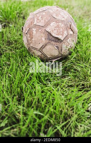 Alte zerrissene vintage Leder Fußball auf Gras - Geschichte Des Fußballs Stockfoto