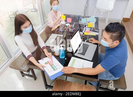 Asiatische Kleinunternehmen Start-up multirassische Arbeit bei Private Home Office soziale Distanzierung unter Coronavirus Ausbruch. Geschäftsleute zeigen und reden Stockfoto