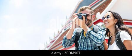 Interracial Tourist paar Fotos während der Sommerferien Reise in Bangkok Thailand mit Thai-Tempel im Hintergrund, Panorama-Banner Stockfoto