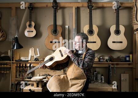 Der walisische Gitarrenbauer Paul Beauchamp arbeitet an einer handgefertigten Akustikgitarre in seiner Werkstatt in Roath, Cardiff Stockfoto