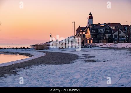 Schneebedeckter Strand während wnter von Urk Leuchtturm in den Niederlanden. Kaltes Winterwetter in den Niederlanden Stockfoto