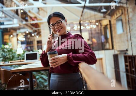 Charmante asiatische Dame, die im modernen Business Center arbeitet Stockfoto